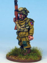 Paratrooper of the 82nd Airborne Division. The cross belts are ammunition bandoliers and he carries a smoke grenade with a white stripe in his webbing.  