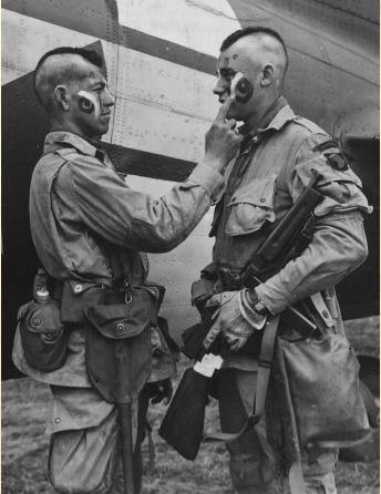 Filthy Thirteen member Clarence Ware applies war paint to Charles Plauda, June 5, 1944. The idea was McNiece's, to honor his Native American heritage and to energize the men for the danger ahead.