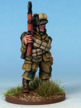 Paratrooper of the 82nd Airborne Division. The cross belts are ammunition bandoliers and he carries a smoke grenade with a white stripe in his webbing.  